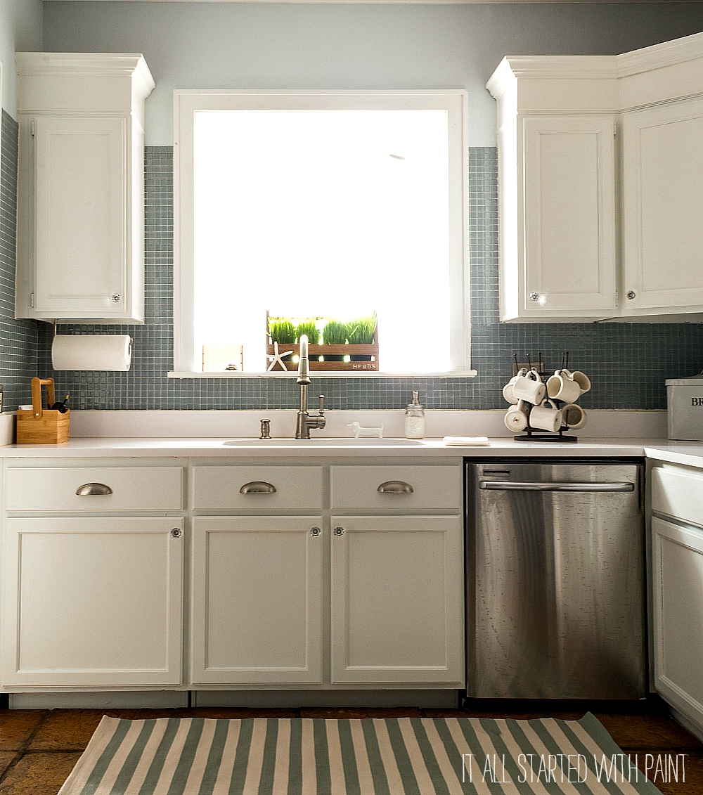 White Kitchen with Painted Builder Grade Cabinets, Blue Gray Tile Back Splash, White Counter Top