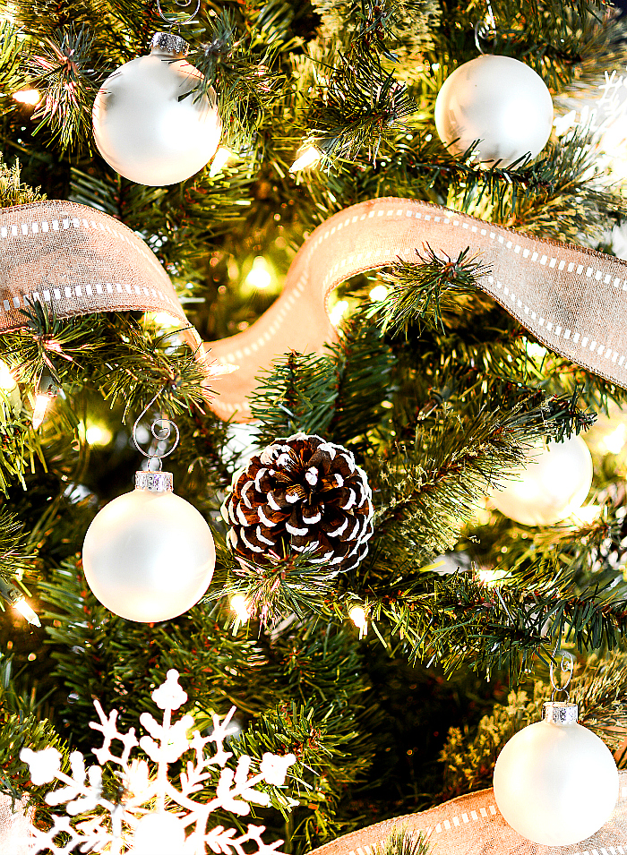 Christmas Tree with Burlap Ribbon and Pine Cones. Natural, Rustic Christmas Tree Idea. White oranments, painted snowy pine cones, snowflakes and burlap ribbon Christmas tree.