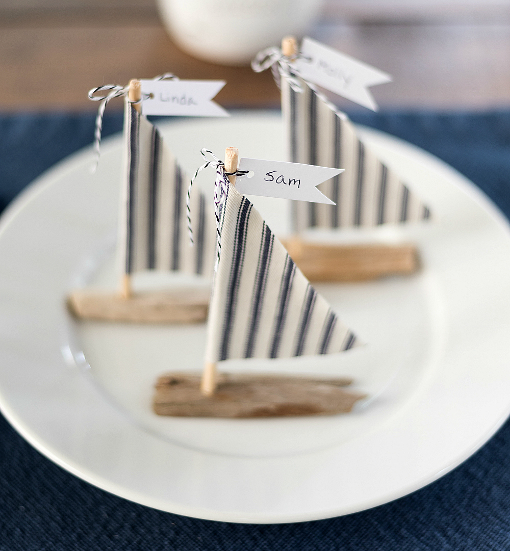 Nautical wedding place setting idea with driftwood sailboats