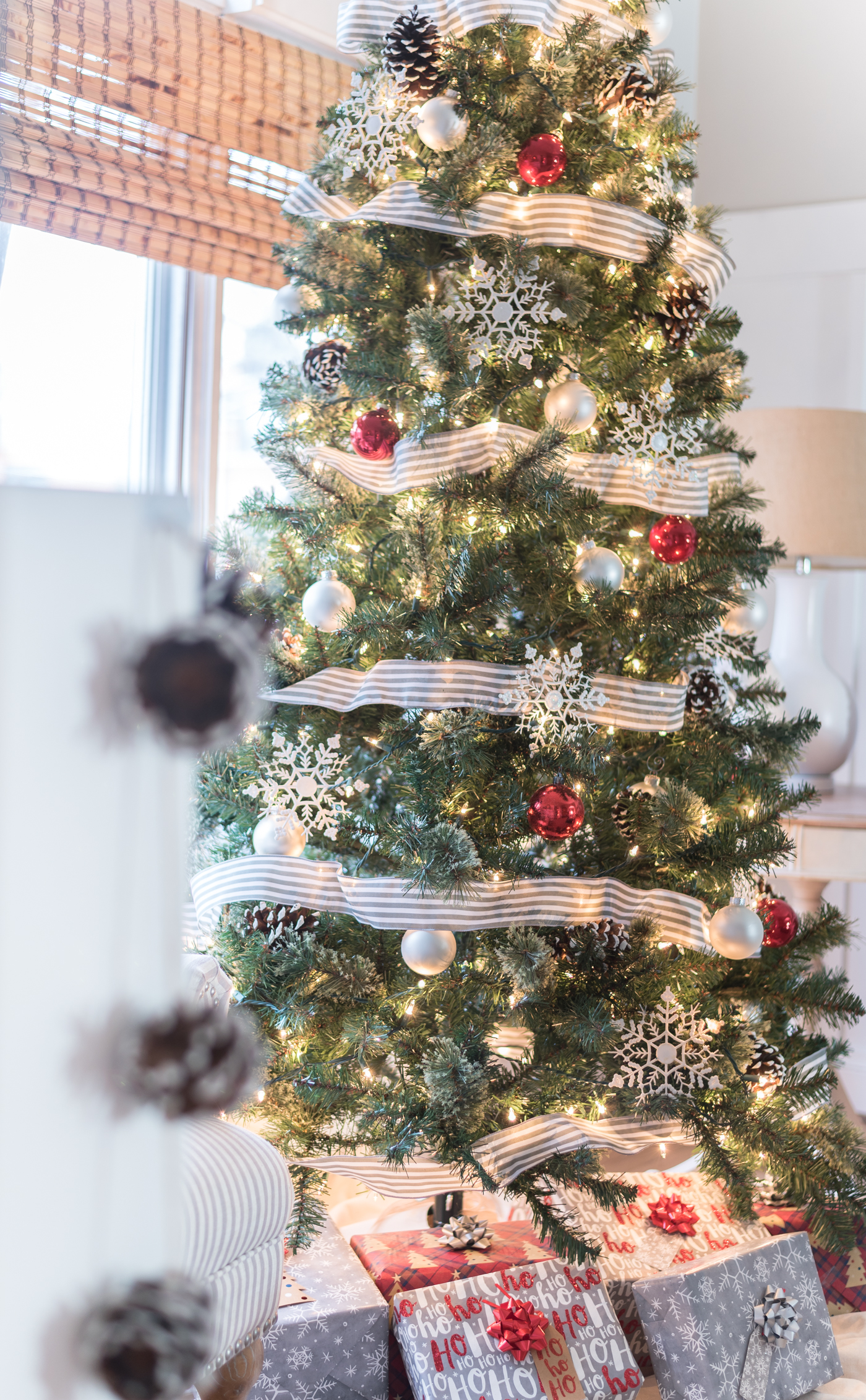 Christmas Tree in Gray, White and Red - Christmas Tree with Painted Pine Cones - Christmas Tree with Dollar Store Snowflakes - Decorating Christmas Tree with Ribbon in Gray and White Stripe.