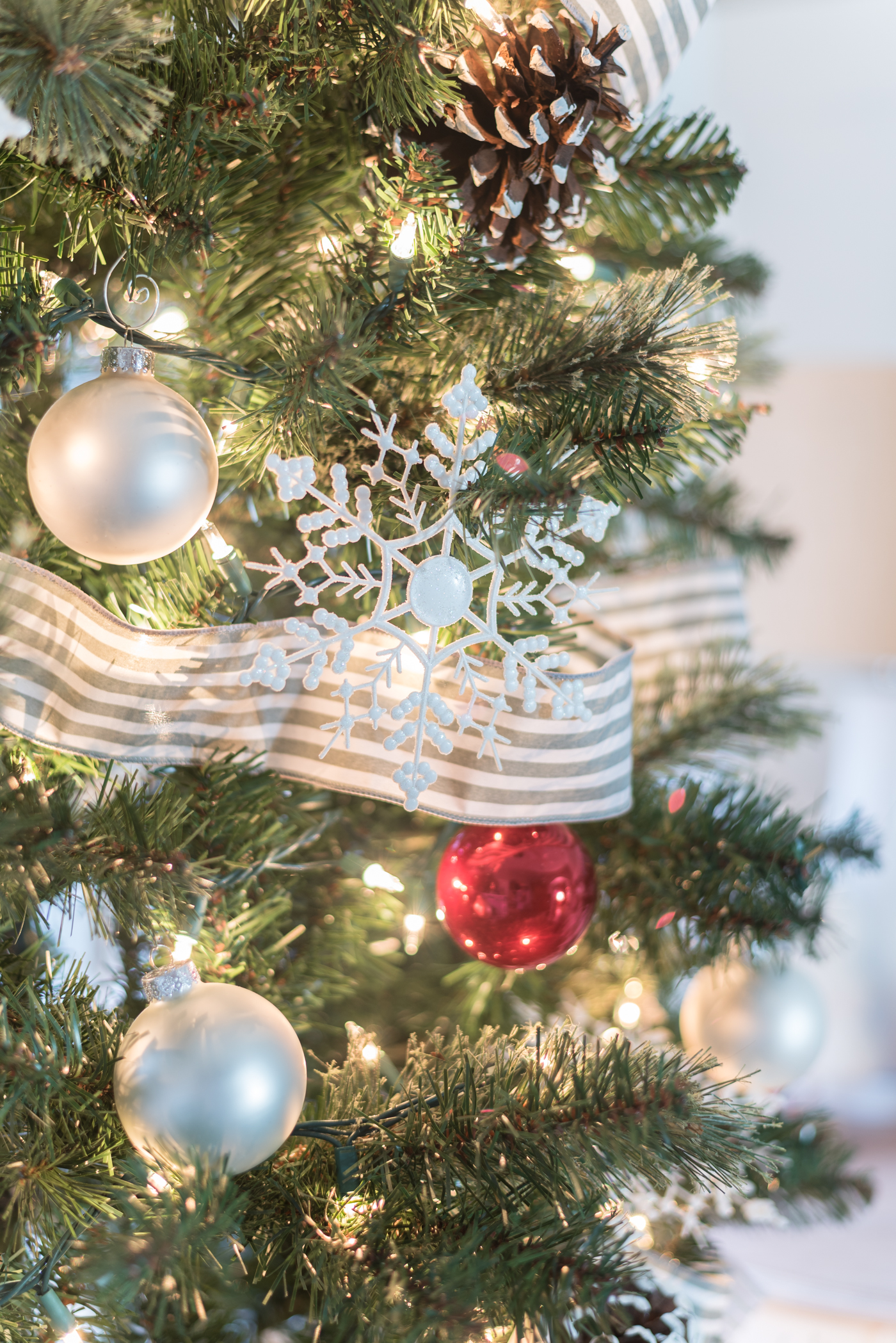 Christmas Tree in Gray, White and Red - Christmas Tree with Painted Pine Cones - Christmas Tree with Dollar Store Snowflakes - Decorating Christmas Tree with Ribbon in Gray and White Stripe.