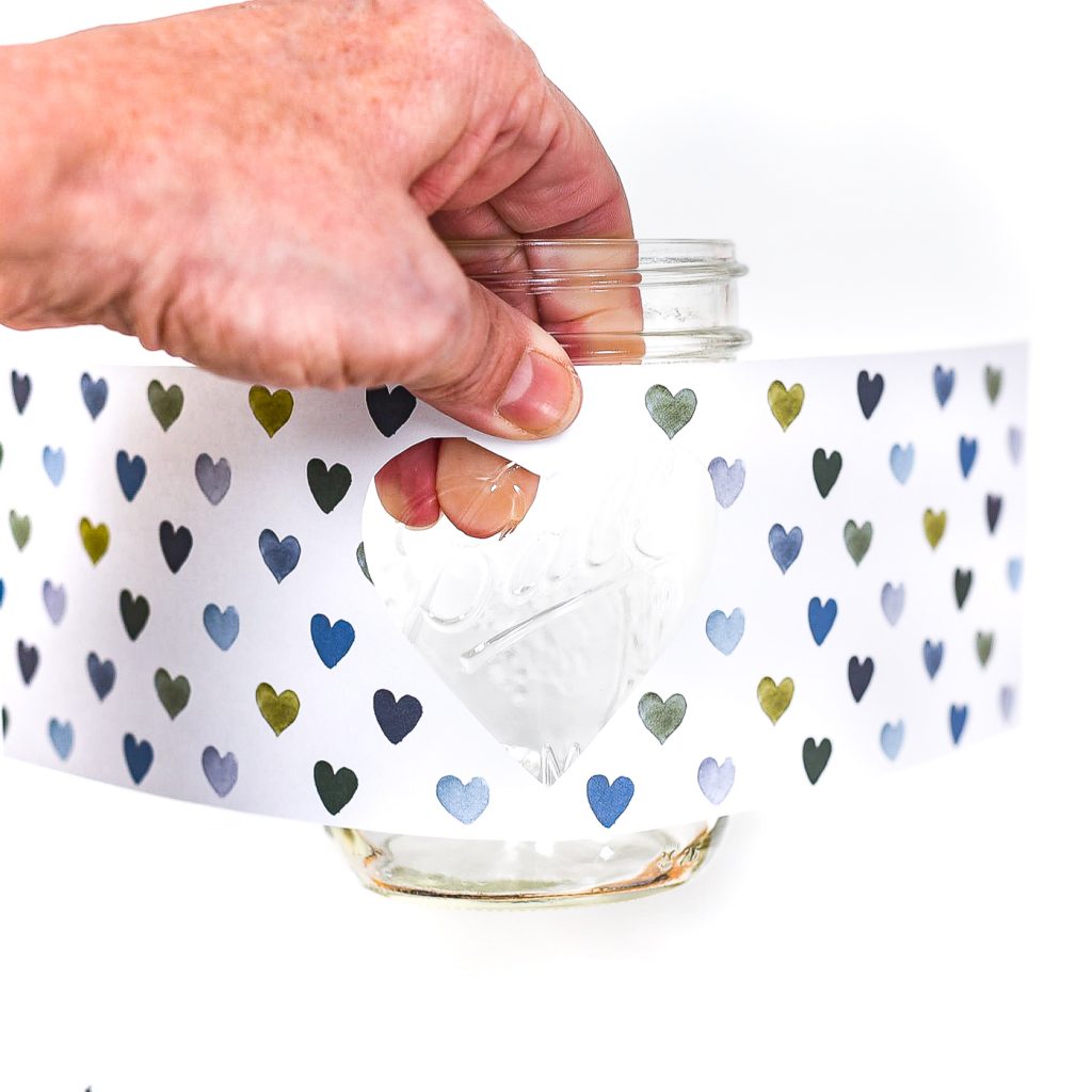 Heart Cut Out Mason Jar Votive - Easy Valentine Craft with Mason Jars, Scrapbook Paper. Scrapbook paper wrapped mason jar with hearts for Valentine's Day. Mason Jar Heart Votive for Valentine's.