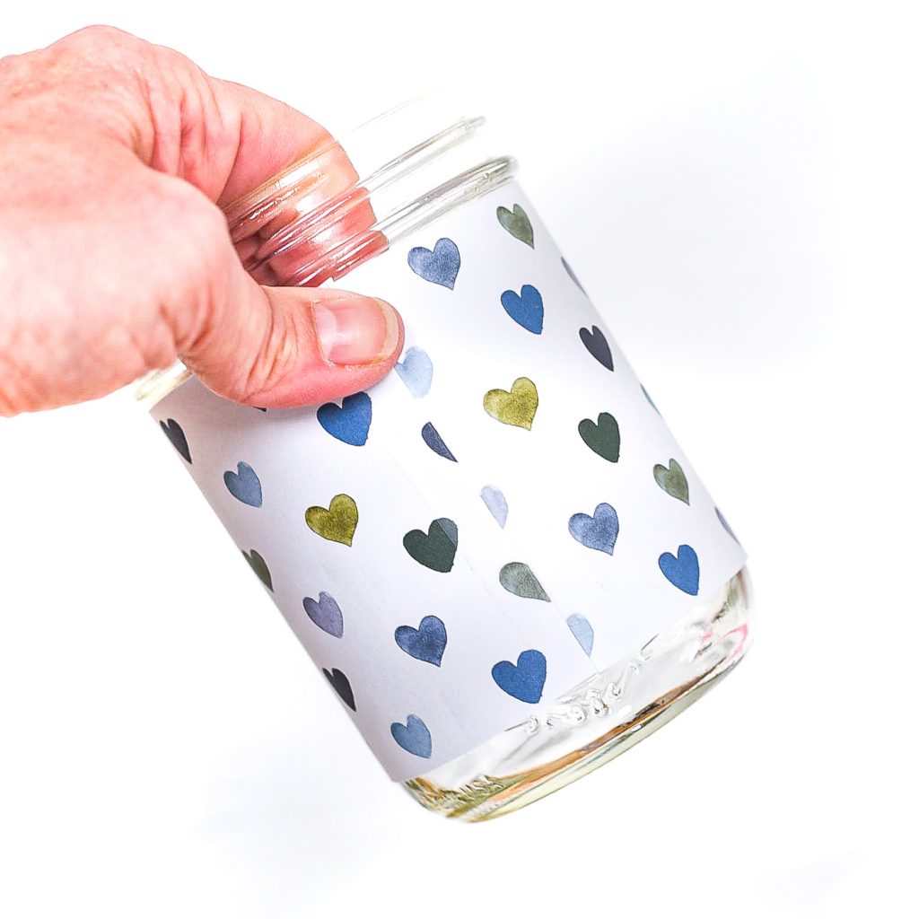 Heart Cut Out Mason Jar Votive - Easy Valentine Craft with Mason Jars, Scrapbook Paper. Scrapbook paper wrapped mason jar with hearts for Valentine's Day. Mason Jar Heart Votive for Valentine's.