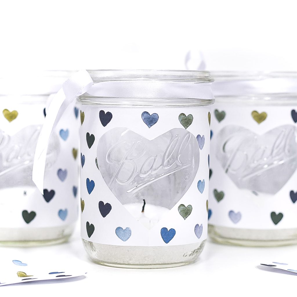 Heart Cut Out Mason Jar Votive - Easy Valentine Craft with Mason Jars, Scrapbook Paper. Scrapbook paper wrapped mason jar with hearts for Valentine's Day. Mason Jar Heart Votive for Valentine's.