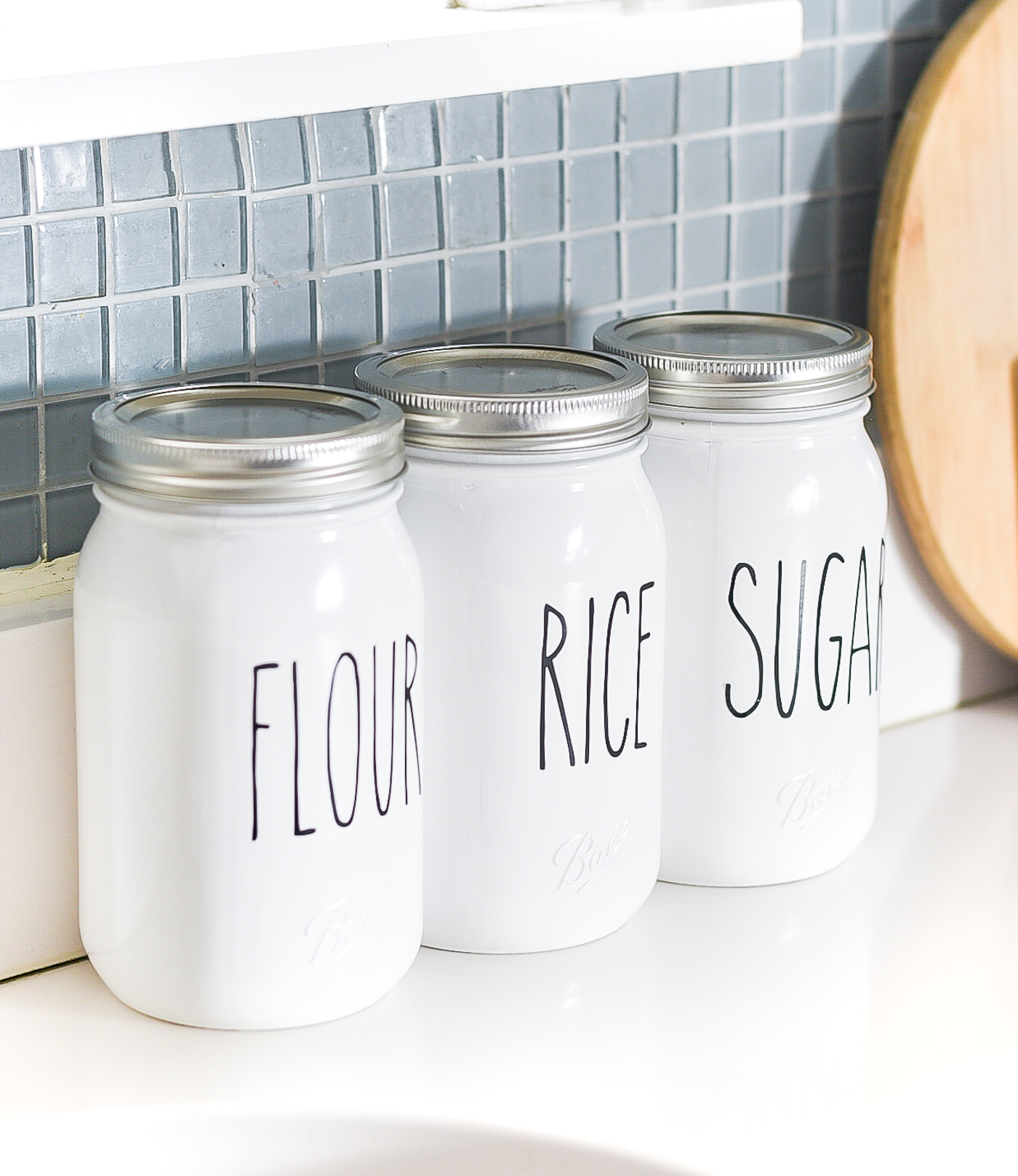 Rae Dunn-inspired mason jar kitchen canisters. Mason jar canister ideas. How to make Rae Dunn pottery, porcelain, canisters. DIY Rae Dunn masons jars.