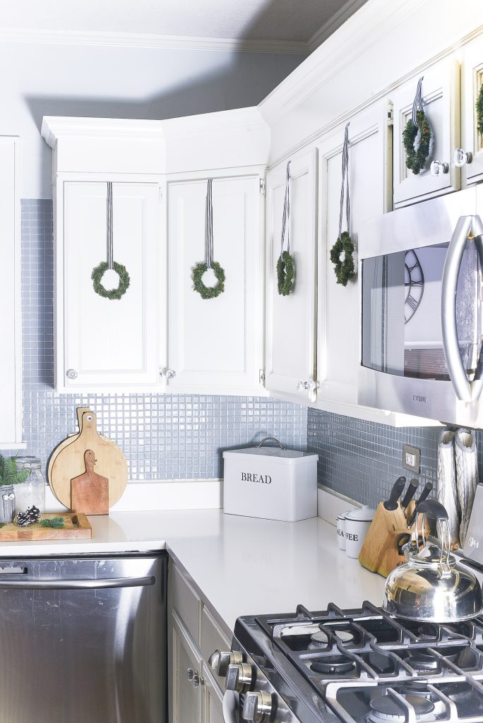 Christmas Kitchen with Mini Wreaths on Kitchen Cabinet Doors. How to Hange Mini Wreaths on Cabinet Doors. Mini Wreaths with Black and White Ribbon Decor Ideas. Black and White Christmas Decor Ideas.