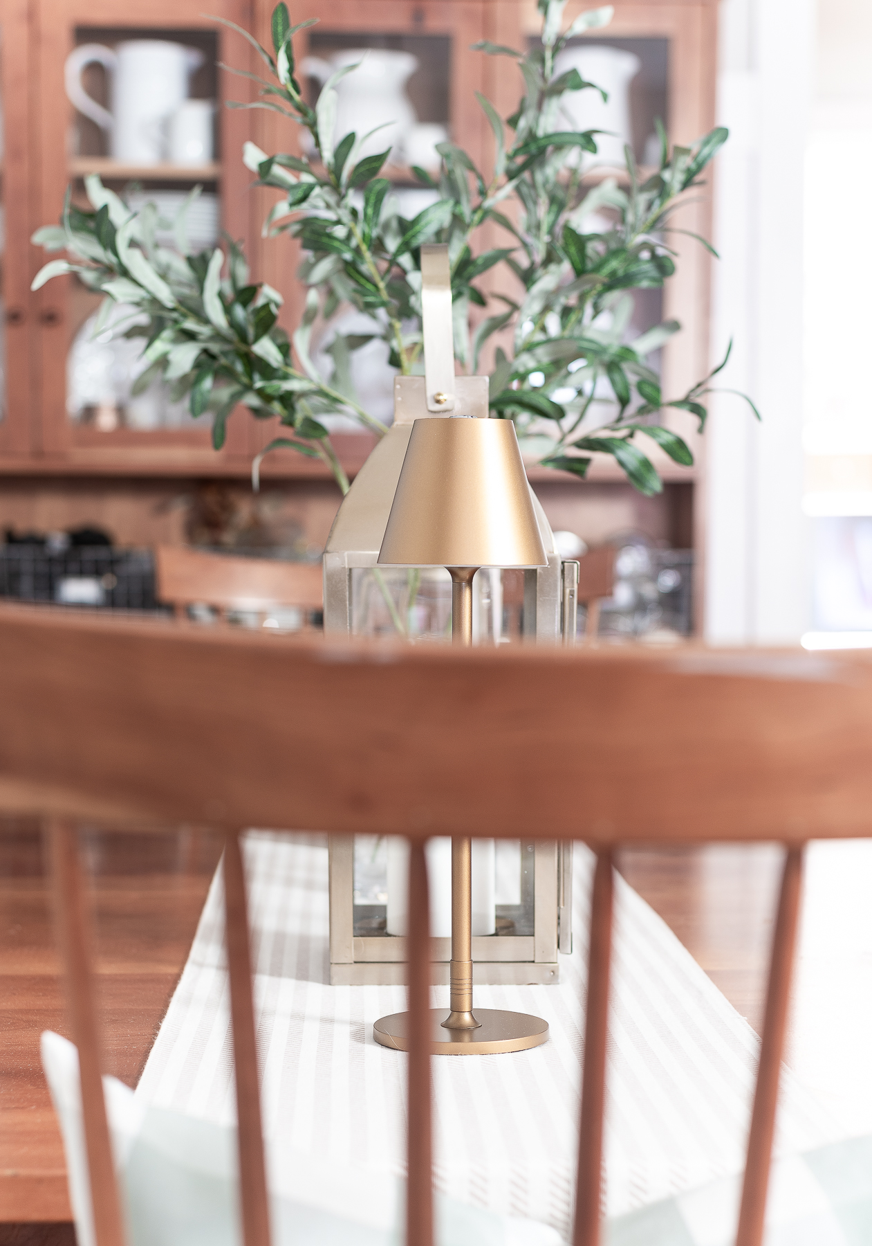 Board and batten dining room - shaker dining room in natural cherry - neutral dining room for spring - tan and white table runner - large gold lanterns - cordless lamps in gold