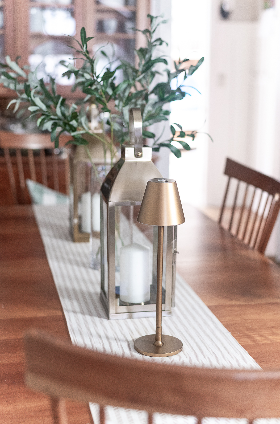 Board and batten dining room - shaker dining room in natural cherry - neutral dining room for spring - tan and white table runner - large gold lanterns - cordless lamps in gold