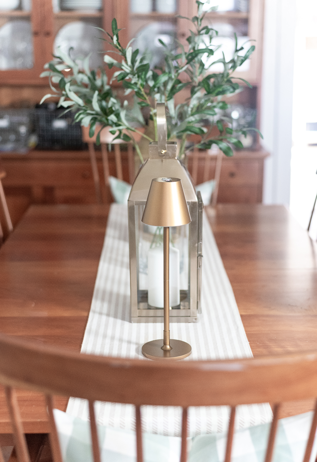 Board and batten dining room - shaker dining room in natural cherry - neutral dining room for spring - tan and white table runner - large gold lanterns - cordless lamps in gold