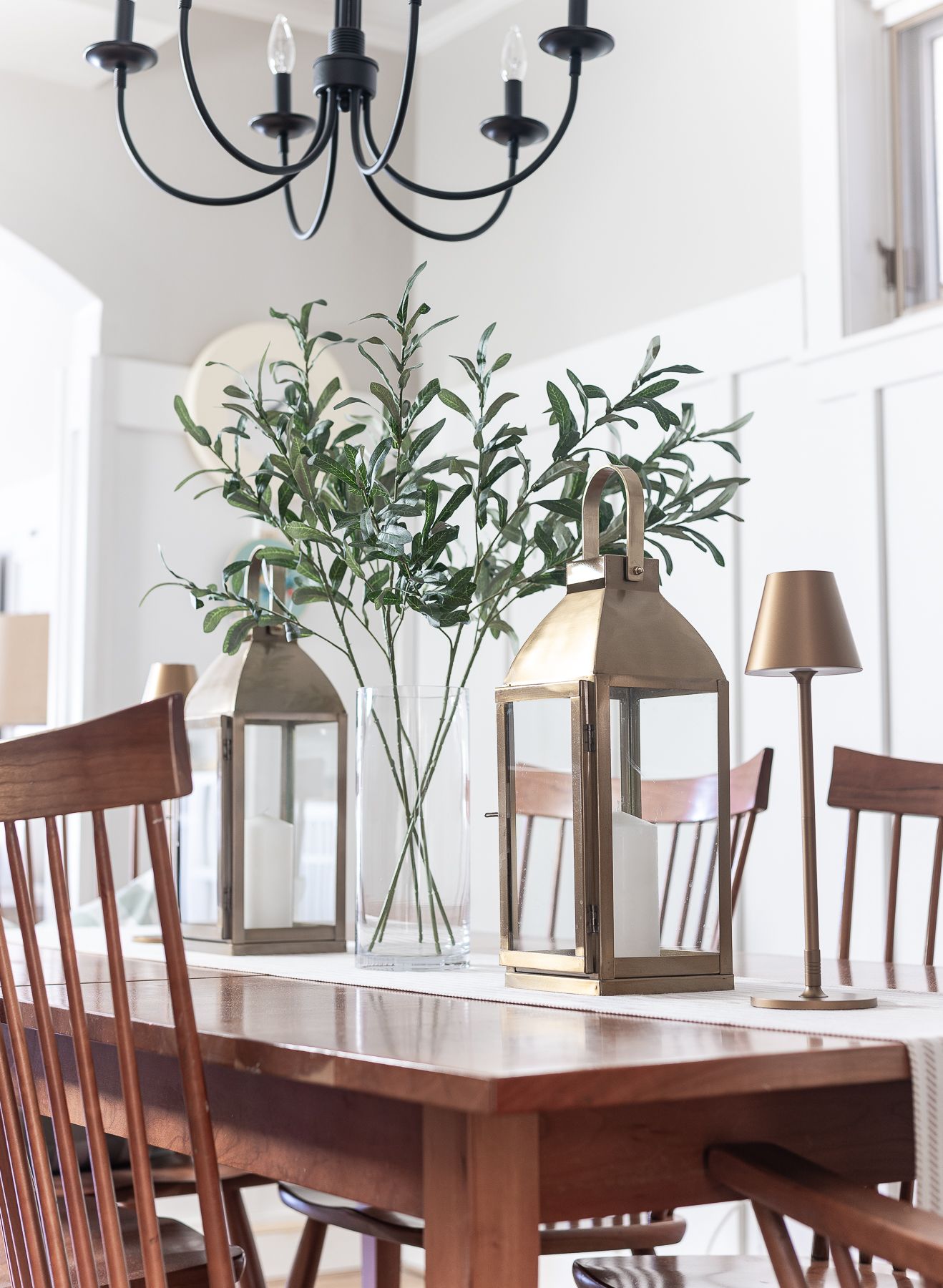 Board and batten dining room - shaker dining room in natural cherry - neutral dining room for spring - tan and white table runner - large gold lanterns - cordless lamps in gold