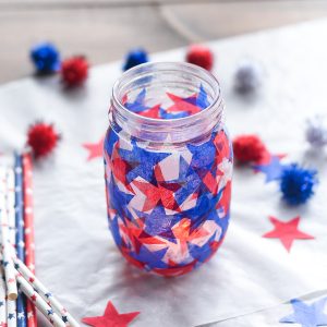Tissue paper stained glass mason jar craft. Red white blue tissue paper craft. Mod Podge jar in red, white blue. Star shaped tissue paper decoupage mason.