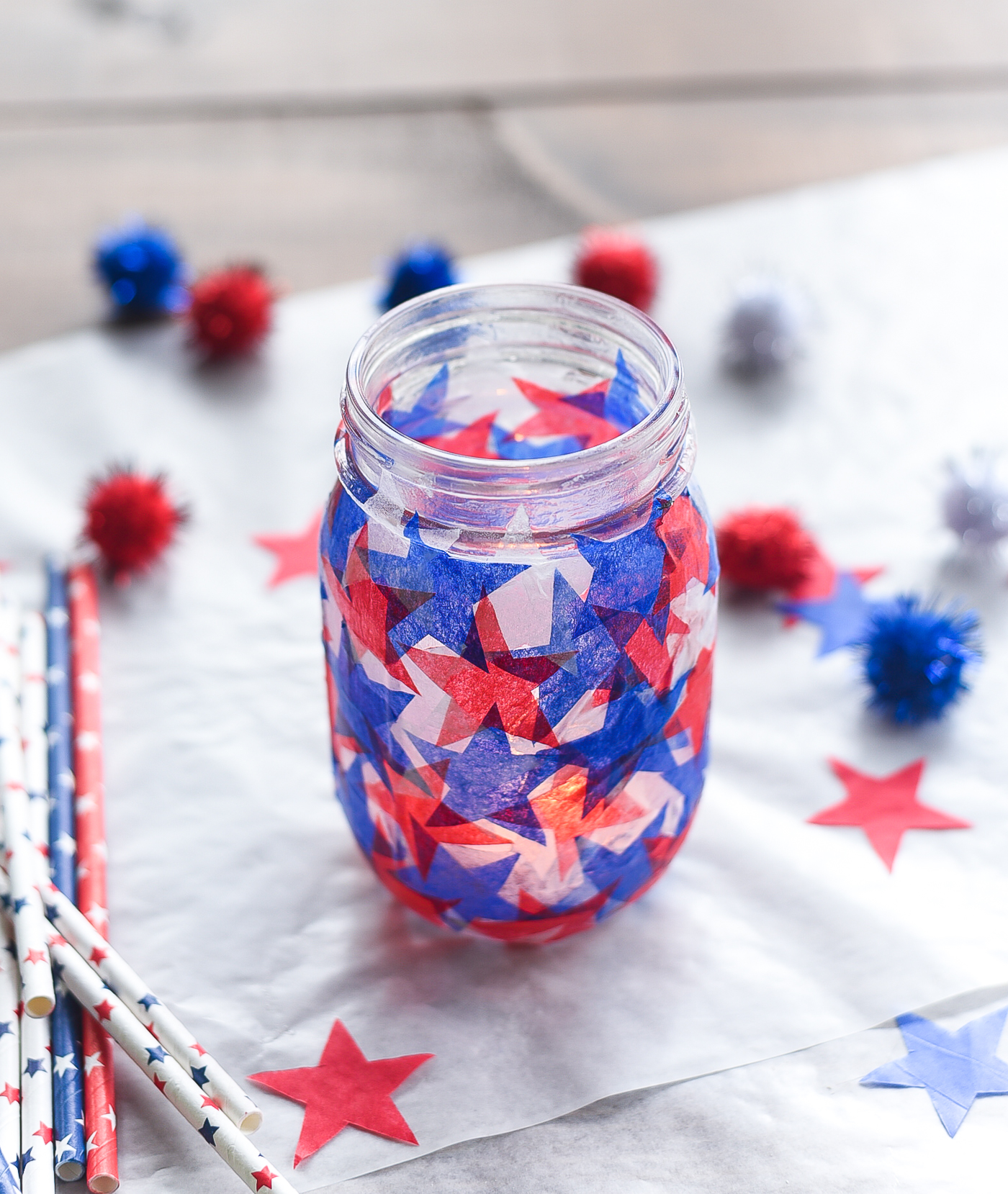 Tissue paper stained glass mason jar craft. Red white blue tissue paper craft. Mod Podge jar in red, white blue. Star shaped tissue paper decoupage mason.
