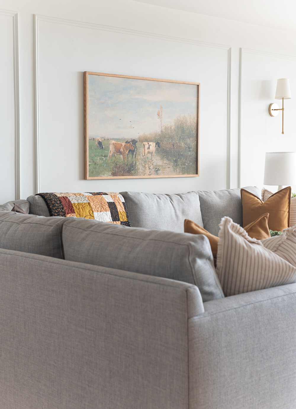 Fall Living Room in Rust, Brown, Mustard, Black, Gray, Neutral. Mustard PIllow. Faux Leather Ottomon from Amazon. Crate & Barrel Barrett Sectional Sofa. Pottery Barn TV Console. Wayfair Side Tables in Light Wood. Vintage Cow Print on Canvas.