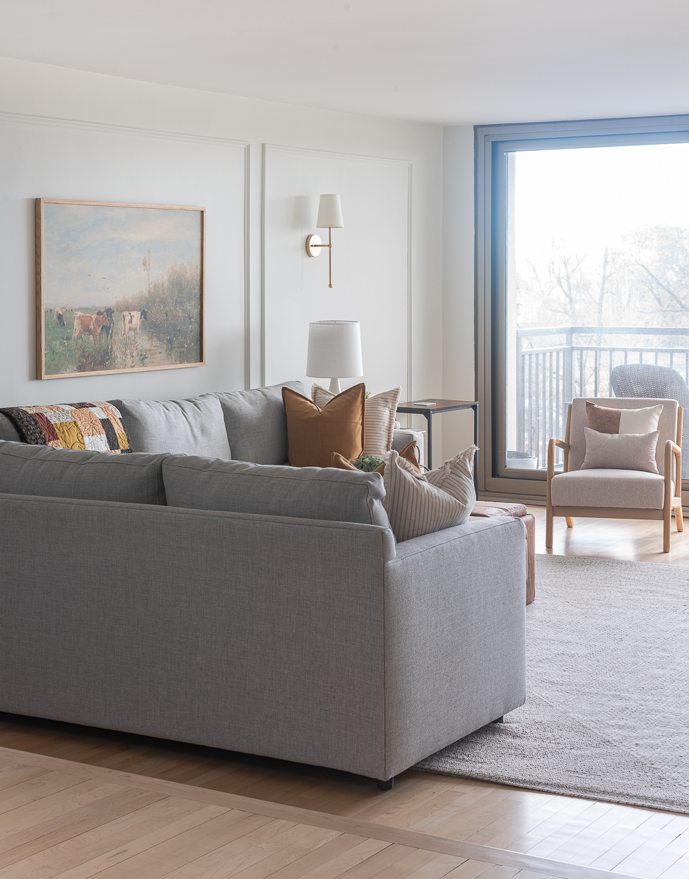 Fall Living Room in Rust, Brown, Mustard, Black, Gray, Neutral. Mustard PIllow. Faux Leather Ottomon from Amazon. Crate & Barrel Barrett Sectional Sofa. Pottery Barn TV Console. Wayfair Side Tables in Light Wood. Vintage Cow Print on Canvas.