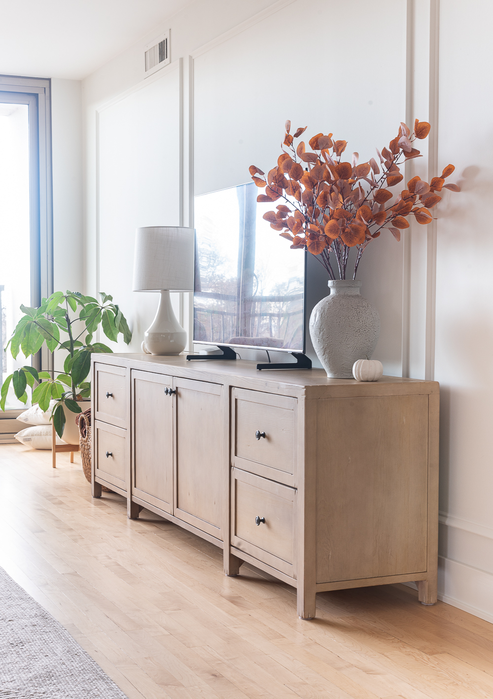 Fall Living Room in Rust, Brown, Mustard, Black, Gray, Neutral. Mustard PIllow. Faux Leather Ottomon from Amazon. Crate & Barrel Barrett Sectional Sofa. Pottery Barn TV Console. Wayfair Side Tables in Light Wood. Vintage Cow Print on Canvas.