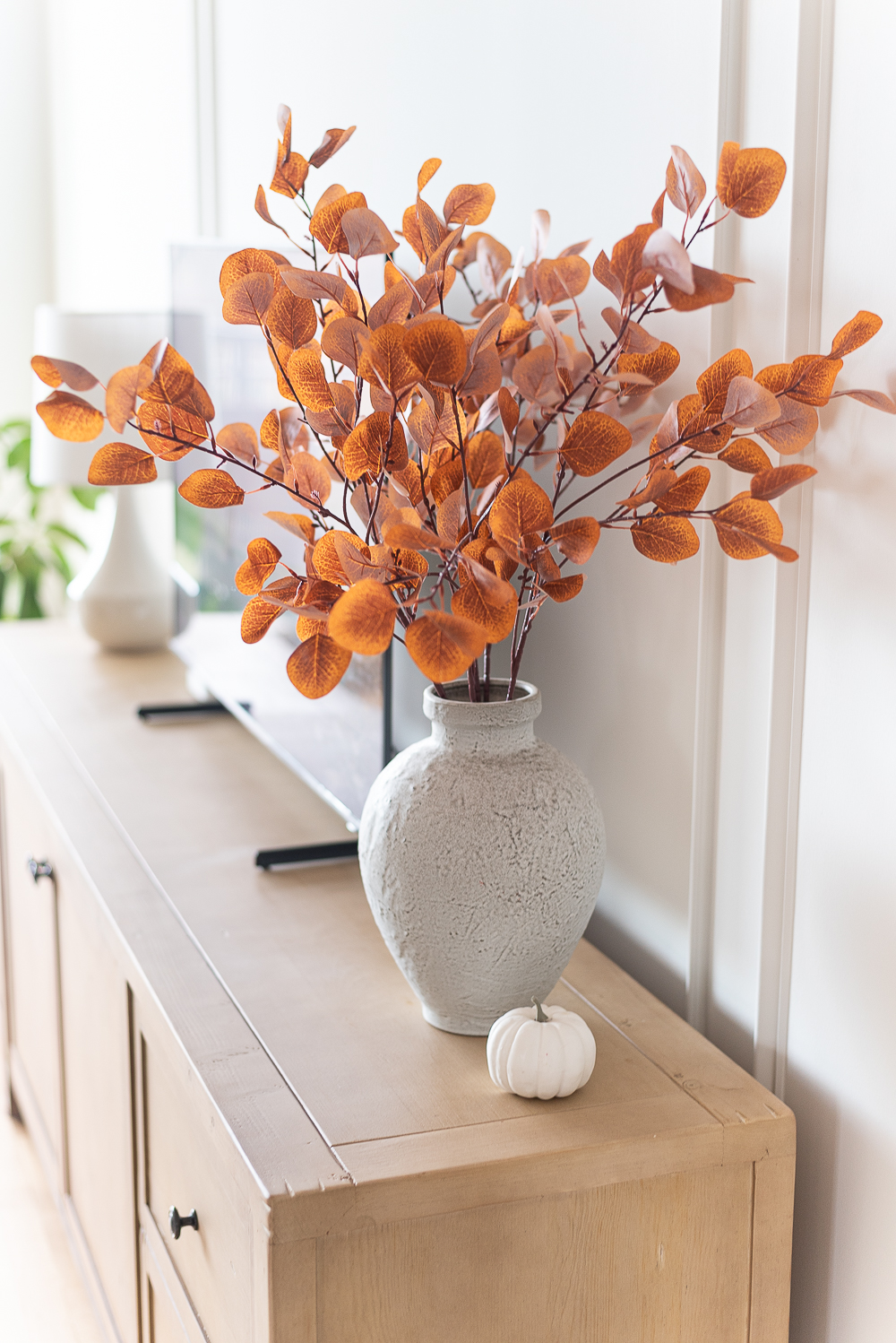 Fall Living Room in Rust, Brown, Mustard, Black, Gray, Neutral. Mustard PIllow. Faux Leather Ottomon from Amazon. Crate & Barrel Barrett Sectional Sofa. Pottery Barn TV Console. Wayfair Side Tables in Light Wood. Vintage Cow Print on Canvas.