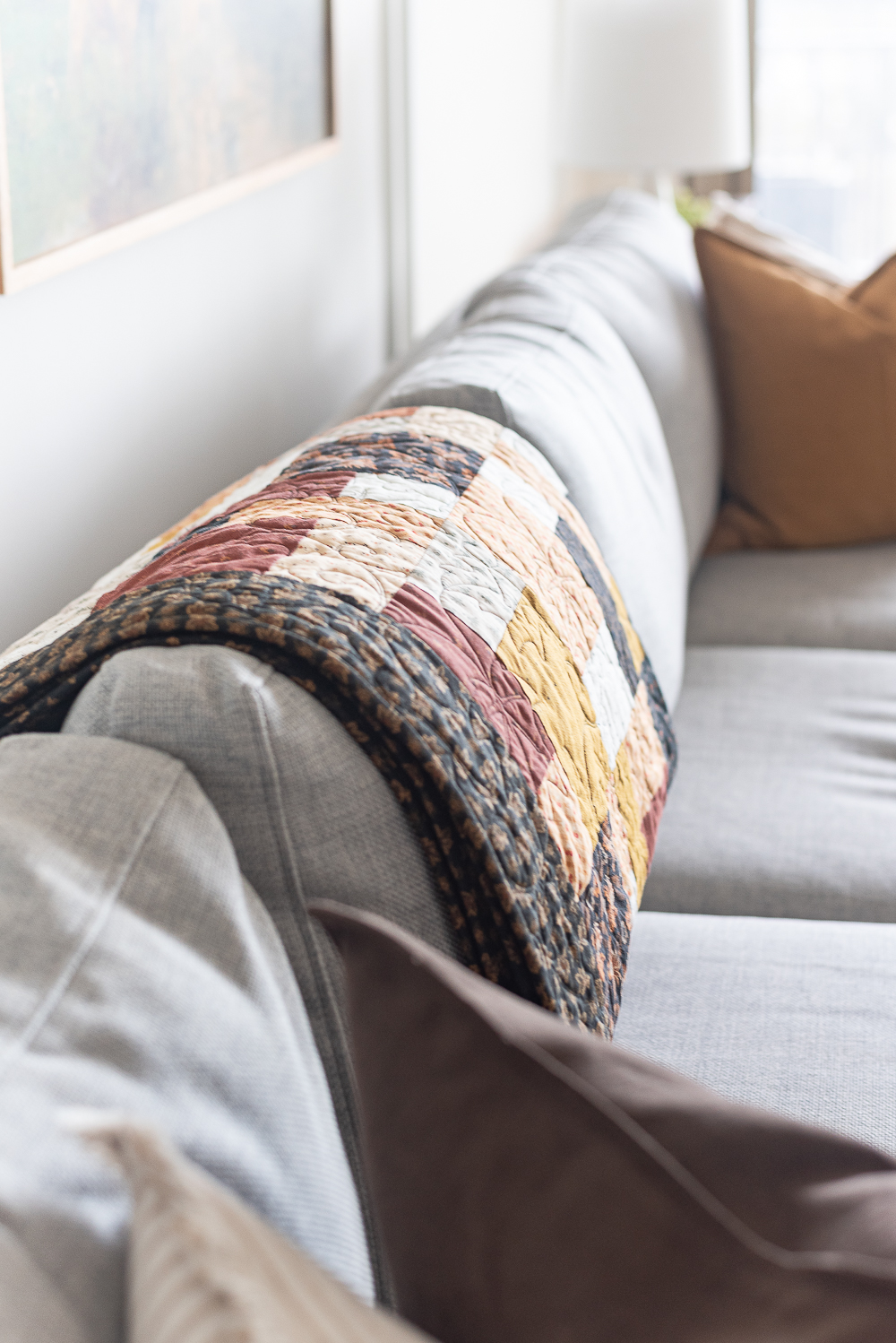 Fall Living Room in Rust, Brown, Mustard, Black, Gray, Neutral. Mustard PIllow. Faux Leather Ottomon from Amazon. Crate & Barrel Barrett Sectional Sofa. Pottery Barn TV Console. Wayfair Side Tables in Light Wood. Vintage Cow Print on Canvas.