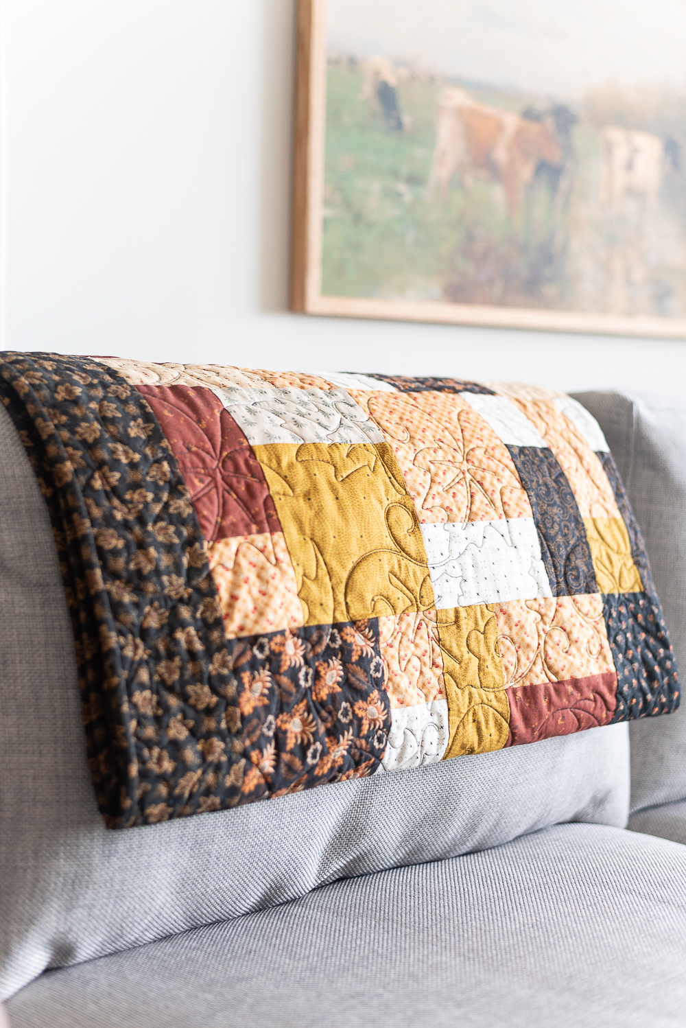 Fall Living Room in Rust, Brown, Mustard, Black, Gray, Neutral. Mustard PIllow. Faux Leather Ottomon from Amazon. Crate & Barrel Barrett Sectional Sofa. Pottery Barn TV Console. Wayfair Side Tables in Light Wood. Vintage Cow Print on Canvas.