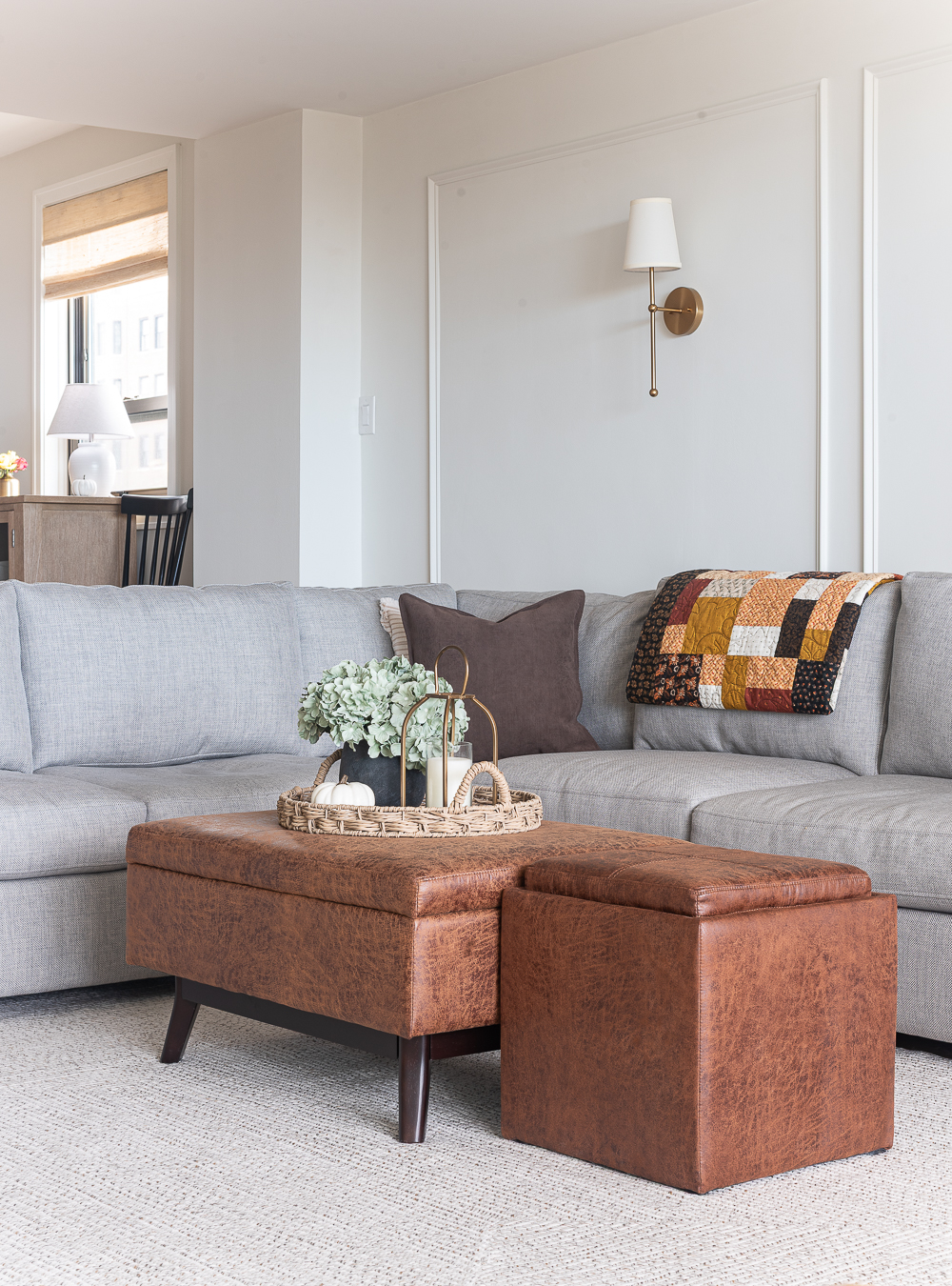 Fall Living Room in Rust, Brown, Mustard, Black, Gray, Neutral. Mustard PIllow. Faux Leather Ottomon from Amazon. Crate & Barrel Barrett Sectional Sofa. Pottery Barn TV Console. Wayfair Side Tables in Light Wood. Vintage Cow Print on Canvas.