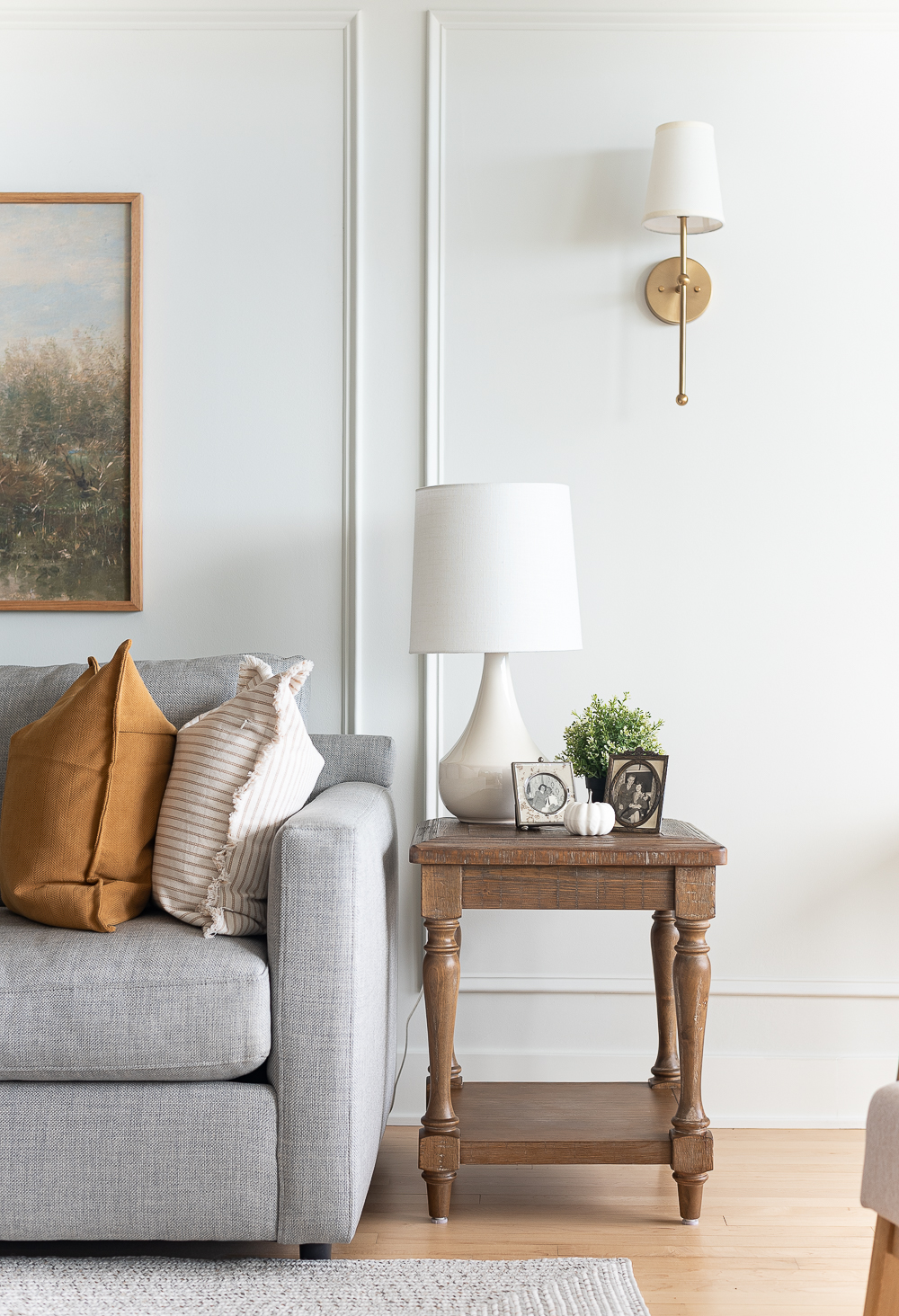 Fall Living Room in Rust, Brown, Mustard, Black, Gray, Neutral. Mustard PIllow. Faux Leather Ottomon from Amazon. Crate & Barrel Barrett Sectional Sofa. Pottery Barn TV Console. Wayfair Side Tables in Light Wood. Vintage Cow Print on Canvas.