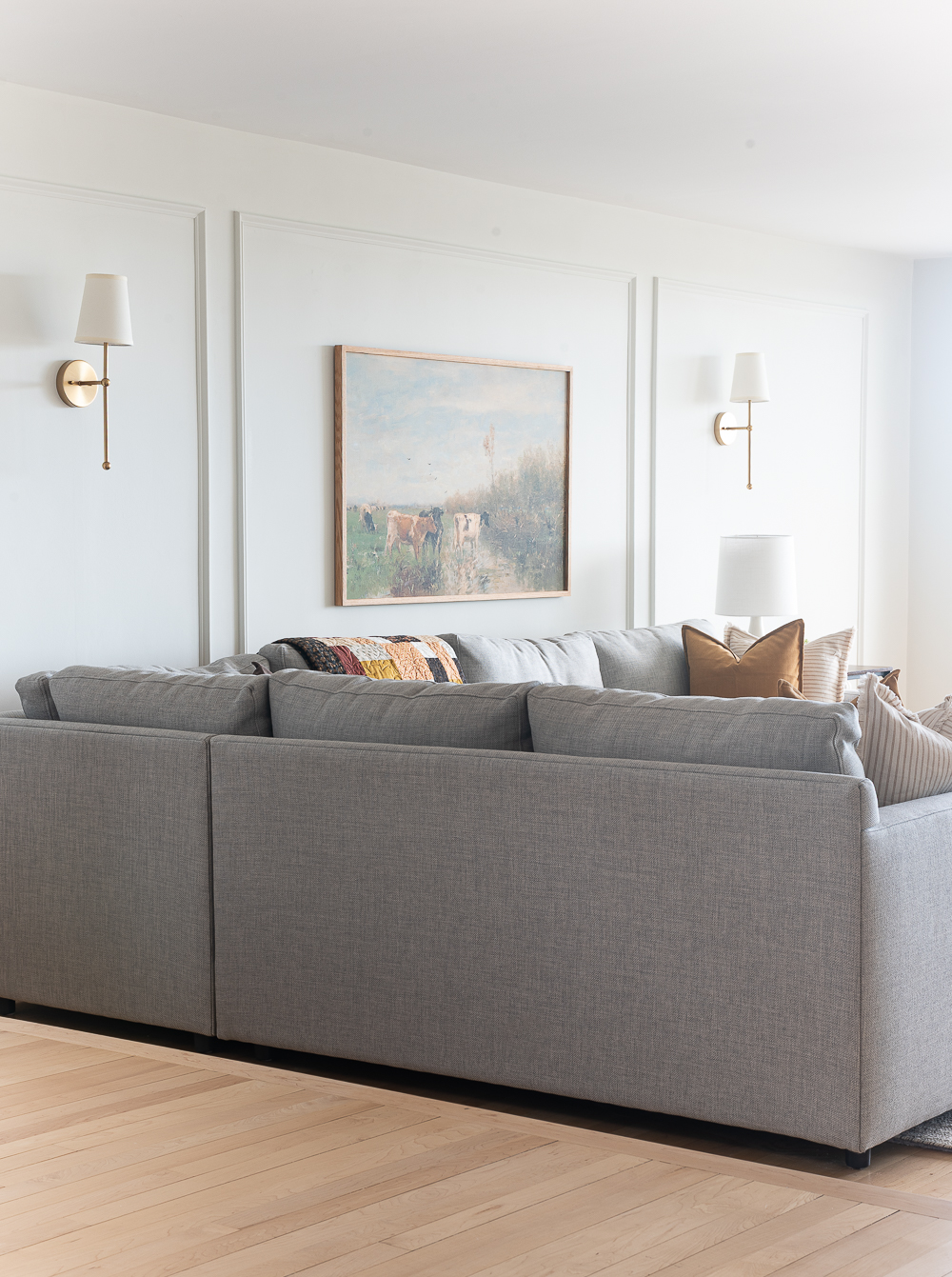 Fall Living Room in Rust, Brown, Mustard, Black, Gray, Neutral. Mustard PIllow. Faux Leather Ottomon from Amazon. Crate & Barrel Barrett Sectional Sofa. Pottery Barn TV Console. Wayfair Side Tables in Light Wood. Vintage Cow Print on Canvas.