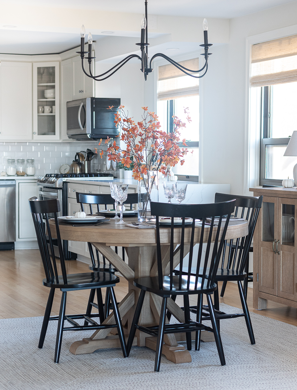 Thanksgiving Table Setting Ideas in Browns, Rusts, Oranges. White pumpkin table settings. Brown and cream ticking cloth napkins. Black flatware. Target decorative plates for fall. Fall Table Setting Ideas. Simple Fall Table. Pottery Barn Round Table Extendable. Wrought Iron Chandelier for Dining Room.