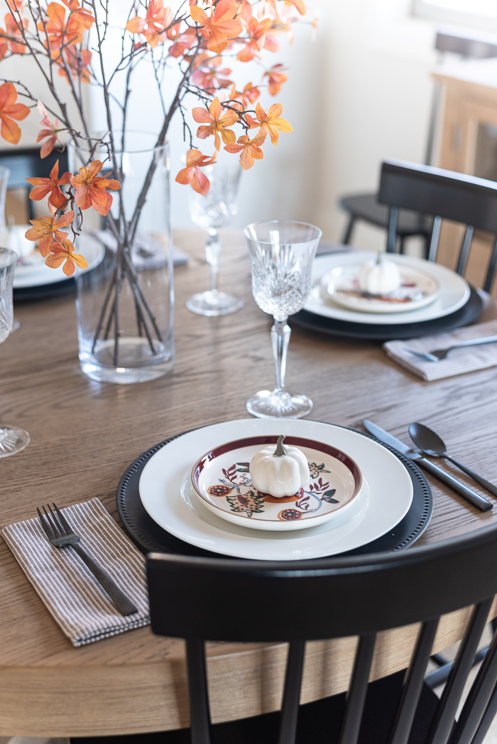 Thanksgiving Table Setting Ideas in Browns, Rusts, Oranges. White pumpkin table settings. Brown and cream ticking cloth napkins. Black flatware. Target decorative plates for fall. Fall Table Setting Ideas. Simple Fall Table.