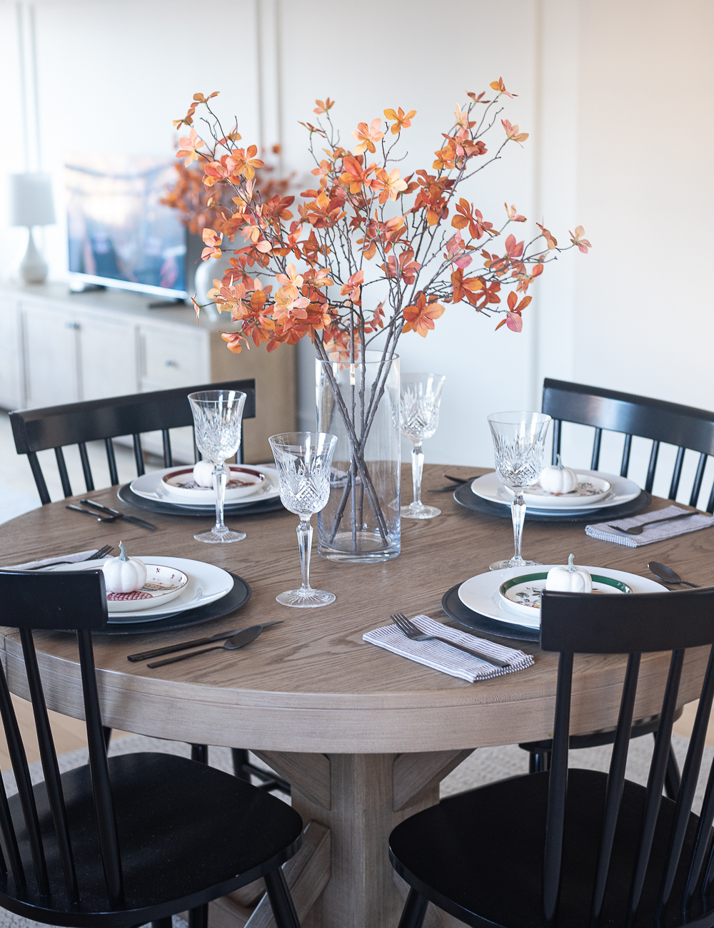 Thanksgiving Table Setting Ideas in Browns, Rusts, Oranges. White pumpkin table settings. Brown and cream ticking cloth napkins. Black flatware. Target decorative plates for fall. Fall Table Setting Ideas. Simple Fall Table.