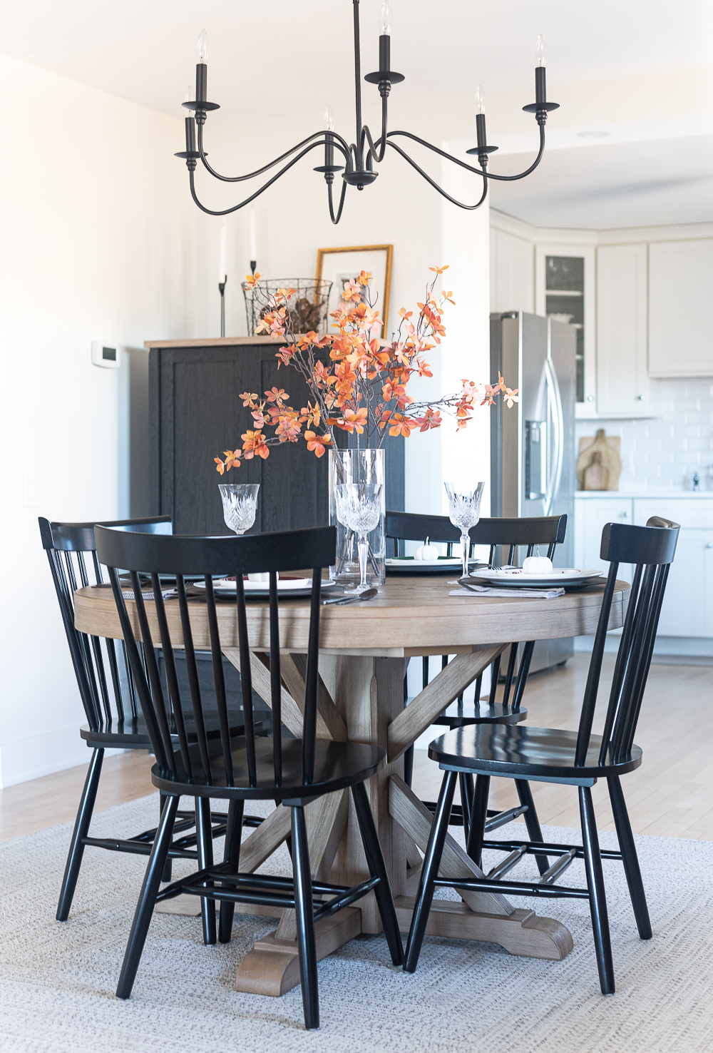 Thanksgiving Table Setting Ideas in Browns, Rusts, Oranges. White pumpkin table settings. Brown and cream ticking cloth napkins. Black flatware. Target decorative plates for fall. Fall Table Setting Ideas. Simple Fall Table. Pottery Barn Round Table Extendable.