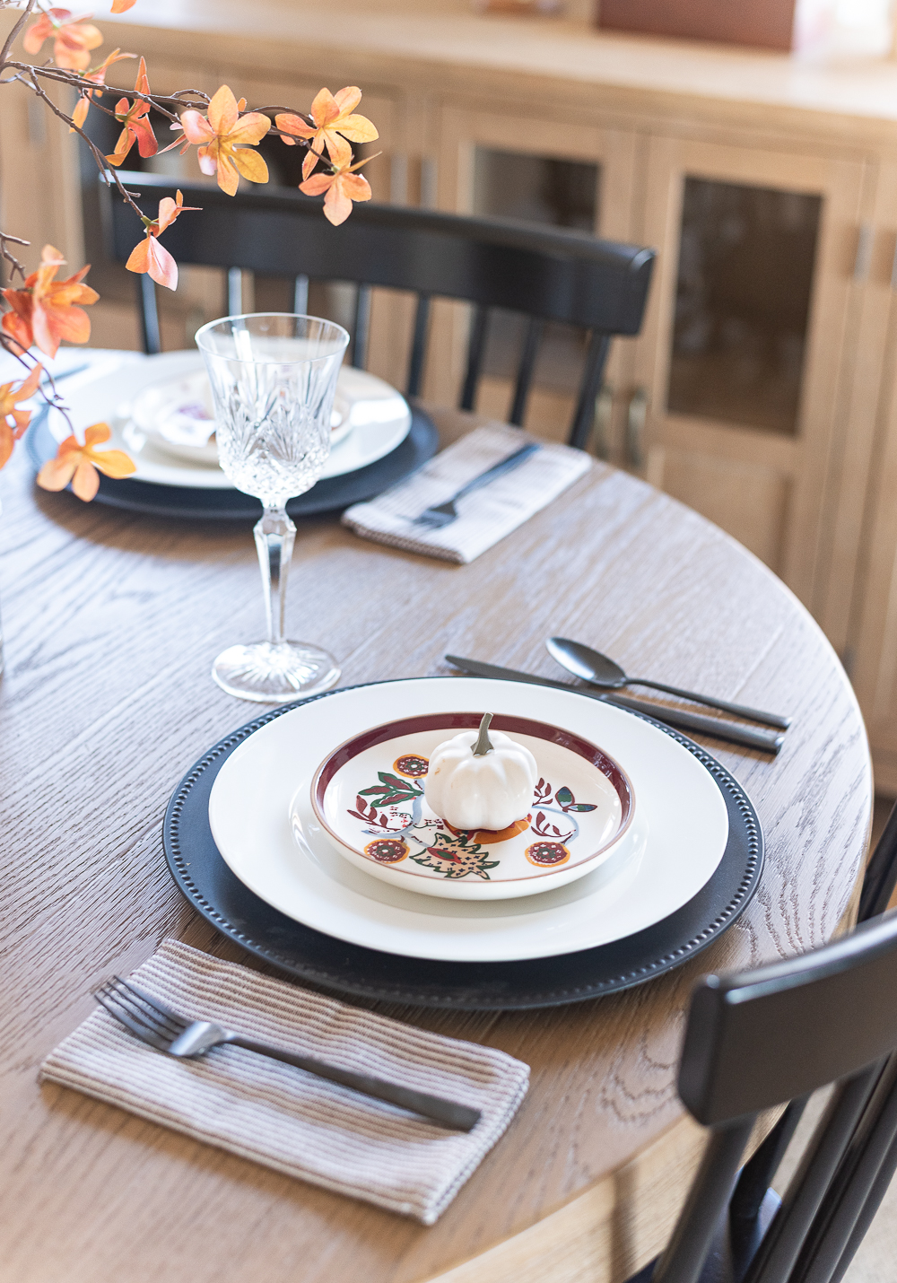 Thanksgiving Table Setting Ideas in Browns, Rusts, Oranges. White pumpkin table settings. Brown and cream ticking cloth napkins. Black flatware. Target decorative plates for fall. Fall Table Setting Ideas. Simple Fall Table.