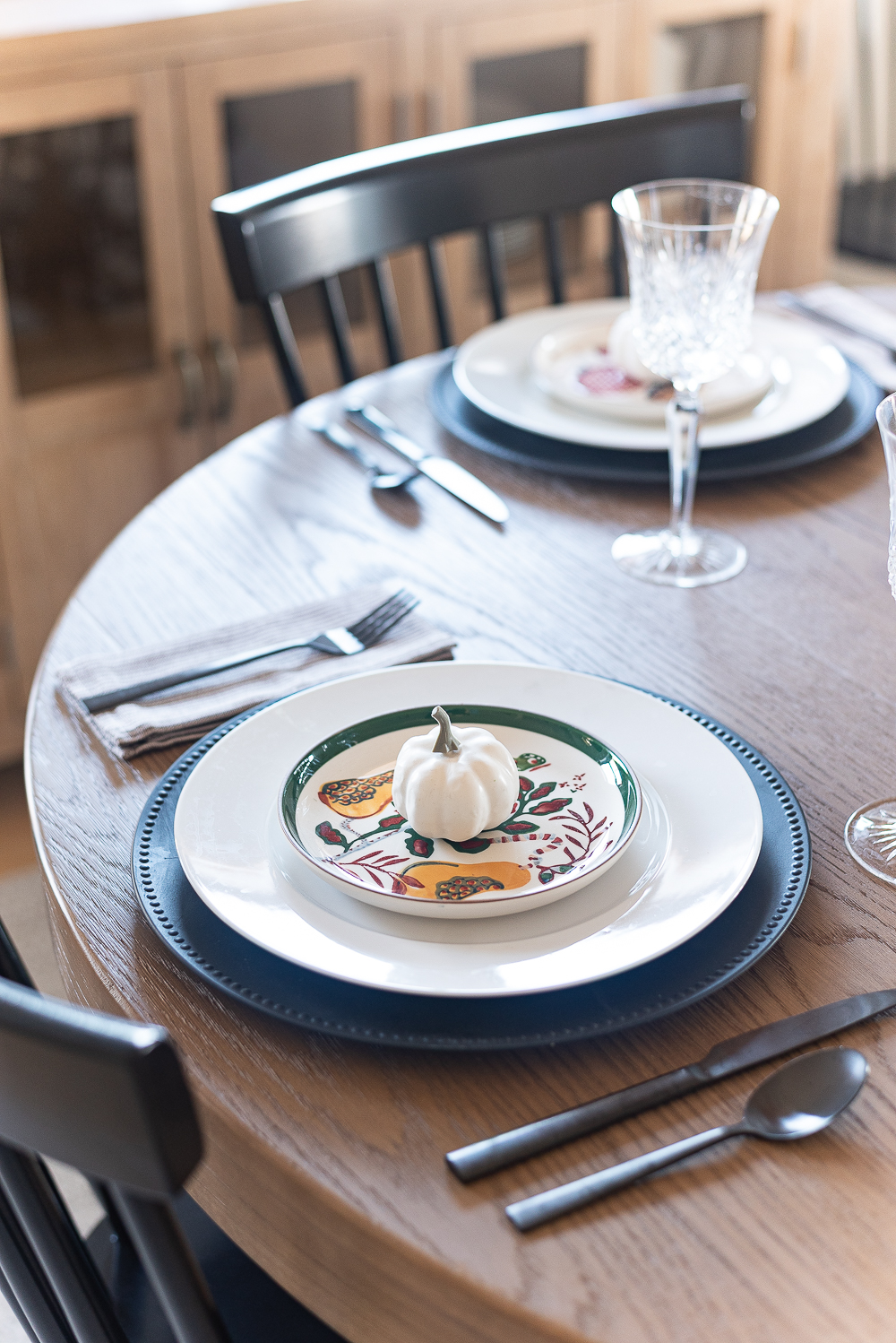 Thanksgiving Table Setting Ideas in Browns, Rusts, Oranges. White pumpkin table settings. Brown and cream ticking cloth napkins. Black flatware. Target decorative plates for fall. Fall Table Setting Ideas. Simple Fall Table.