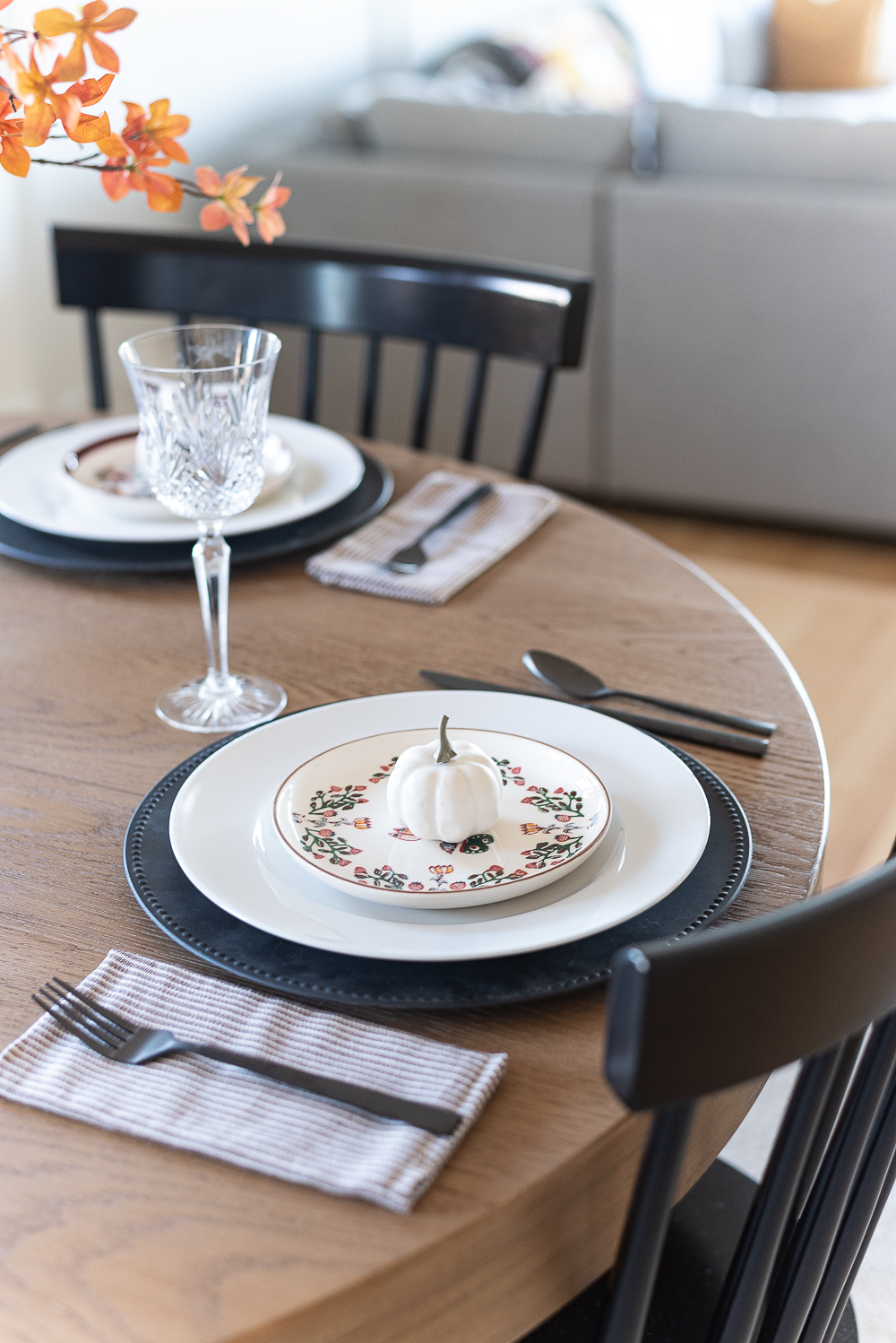 Thanksgiving Table Setting Ideas in Browns, Rusts, Oranges. White pumpkin table settings. Brown and cream ticking cloth napkins. Black flatware. Target decorative plates for fall. Fall Table Setting Ideas. Simple Fall Table.