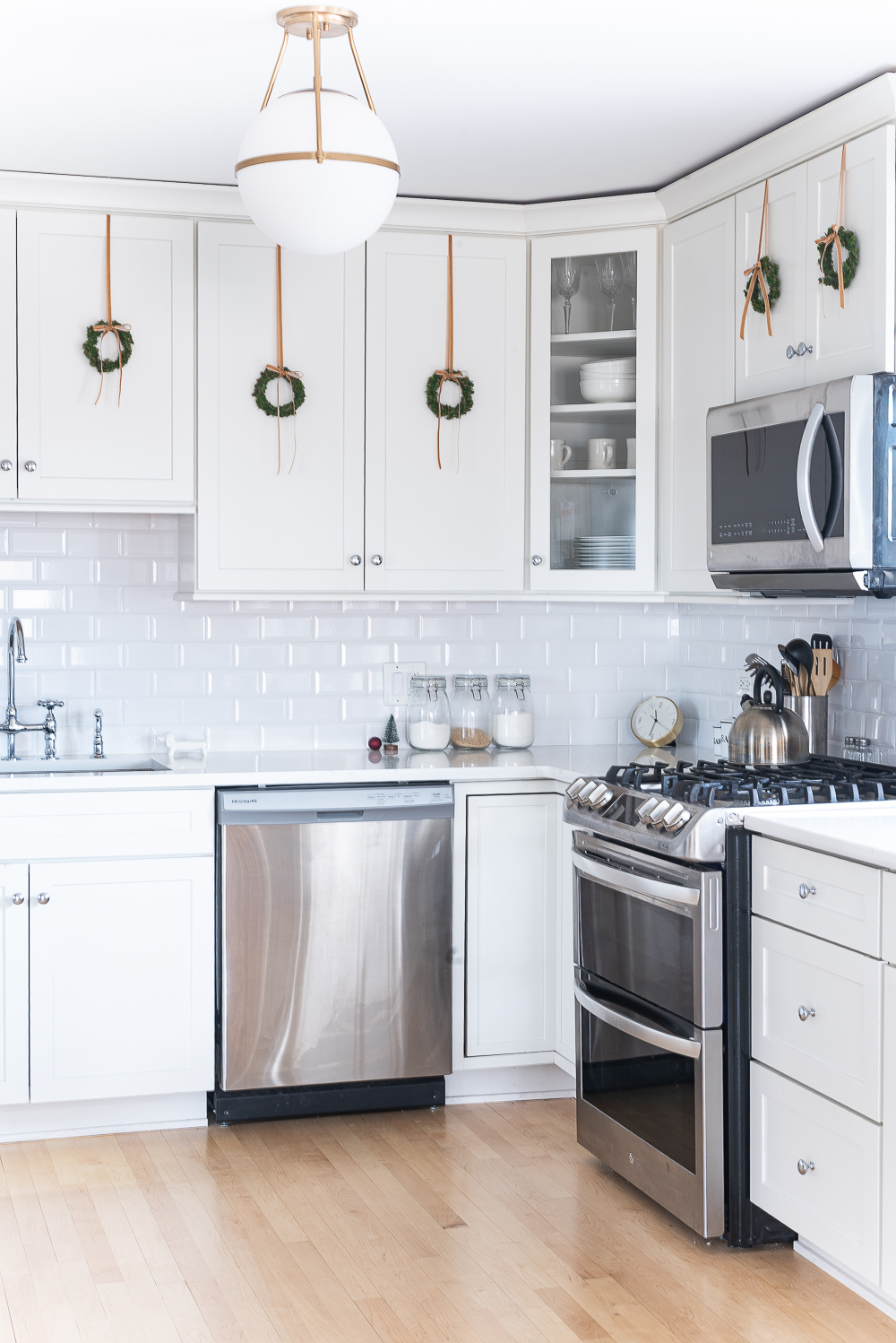 Wreaths on Kitchen Cabinets for Christmas. Decorating the Kitchen for Christmas. Decorating the Kitchen with Mini Wreaths and Velvet Ribbons and Bows.