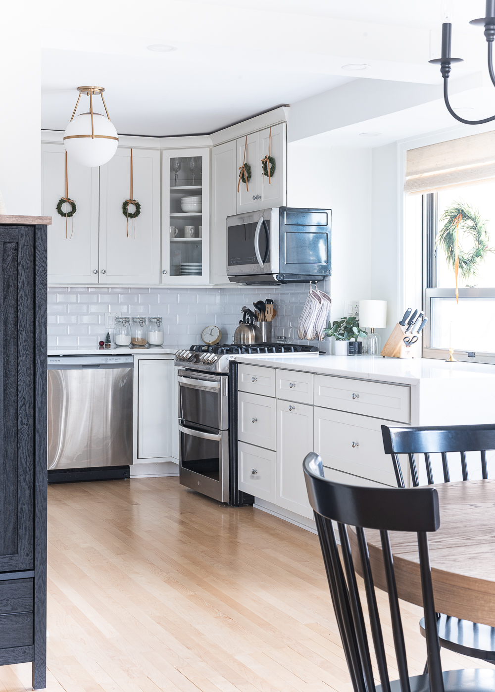 Wreaths on Kitchen Cabinets for Christmas. Decorating the Kitchen for Christmas. Decorating the Kitchen with Mini Wreaths and Velvet Ribbons and Bows.