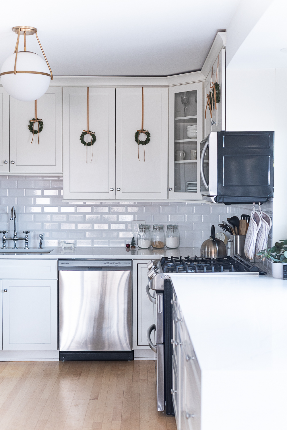 Wreaths on Kitchen Cabinets for Christmas. Decorating the Kitchen for Christmas. Decorating the Kitchen with Mini Wreaths and Velvet Ribbons and Bows.