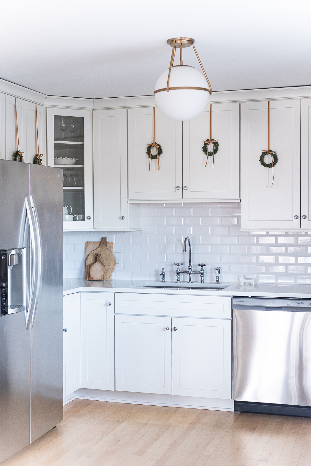 Wreaths on Kitchen Cabinets for Christmas. Decorating the Kitchen for Christmas. Decorating the Kitchen with Mini Wreaths and Velvet Ribbons and Bows.