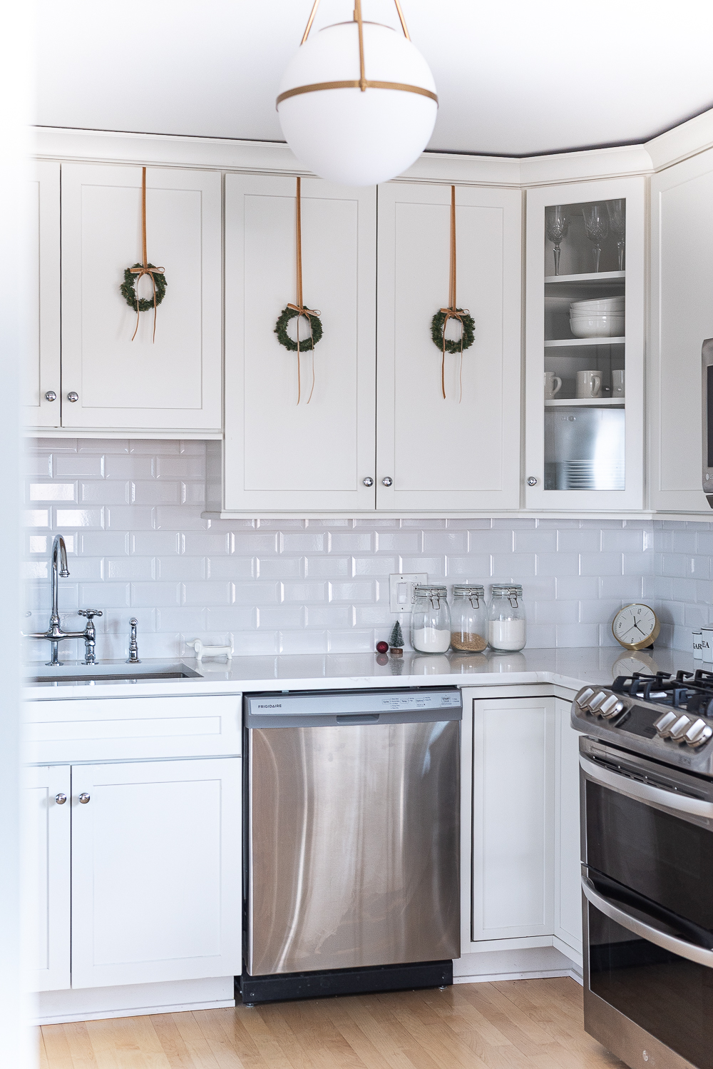 Wreaths on Kitchen Cabinets for Christmas. Decorating the Kitchen for Christmas. Decorating the Kitchen with Mini Wreaths and Velvet Ribbons and Bows.