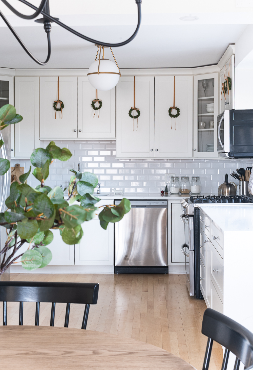 Wreaths on Kitchen Cabinets for Christmas. Decorating the Kitchen for Christmas. Decorating the Kitchen with Mini Wreaths and Velvet Ribbons and Bows.